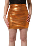 Jupe courte en lamé orange métallique avec fronces, de la marque Dolce & Gabbana, pour un style élégant et audacieux.