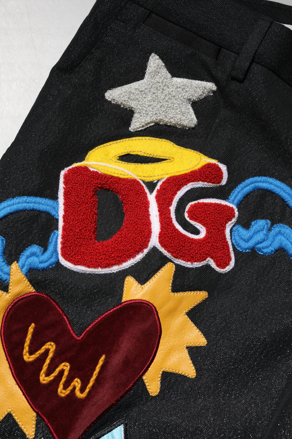 Pantalon noir pour homme Dolce & Gabbana avec broderie graphique et détails élégants.