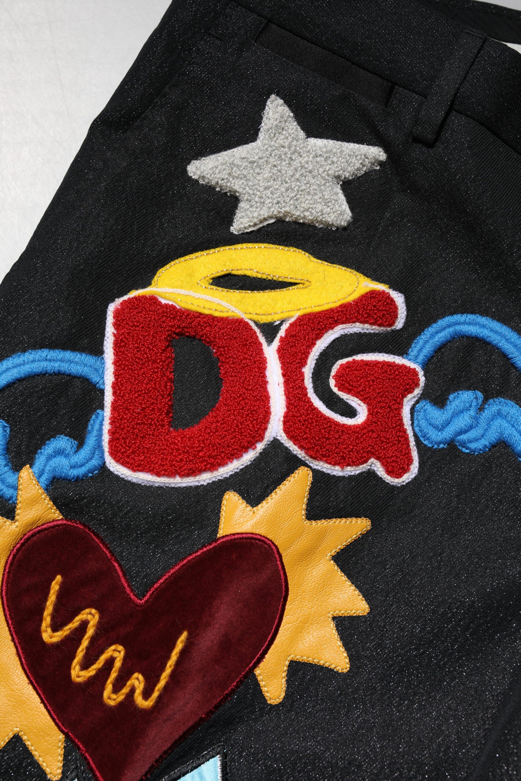 Pantalon noir pour homme Dolce & Gabbana avec broderie graphique et détails élégants.