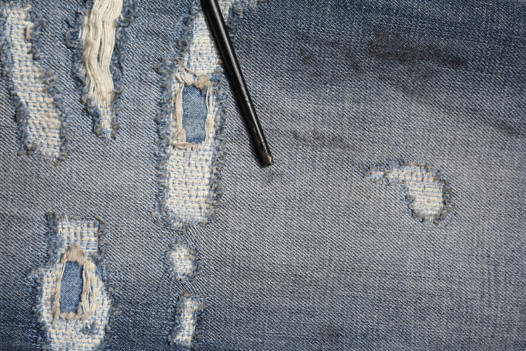 Jeans homme Dolce & Gabbana en coton bleu délavé et usé, style tattered avec déchirures et finitions modernes.