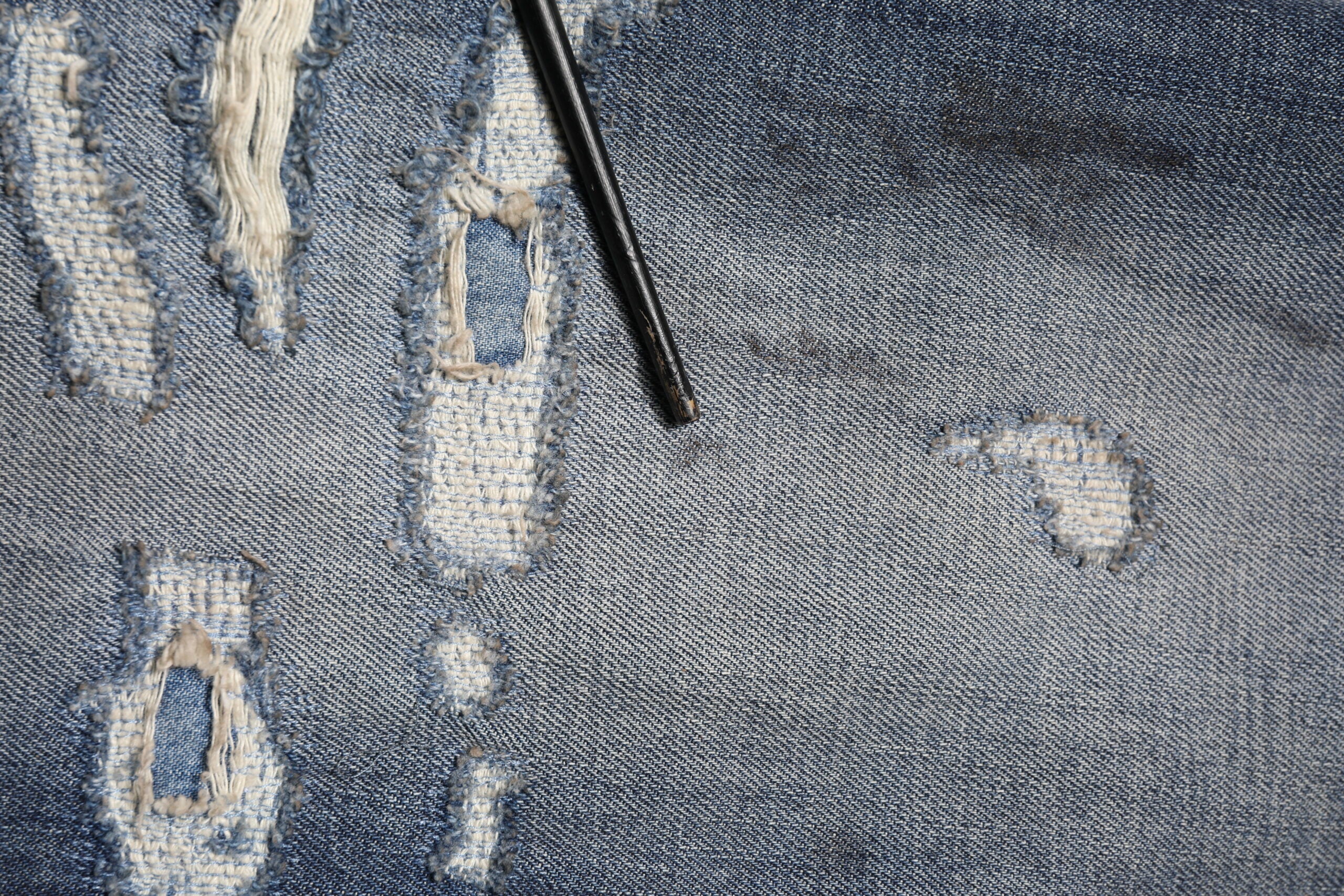 Jeans homme Dolce & Gabbana en coton bleu délavé et usé, style tattered avec déchirures et finitions modernes.
