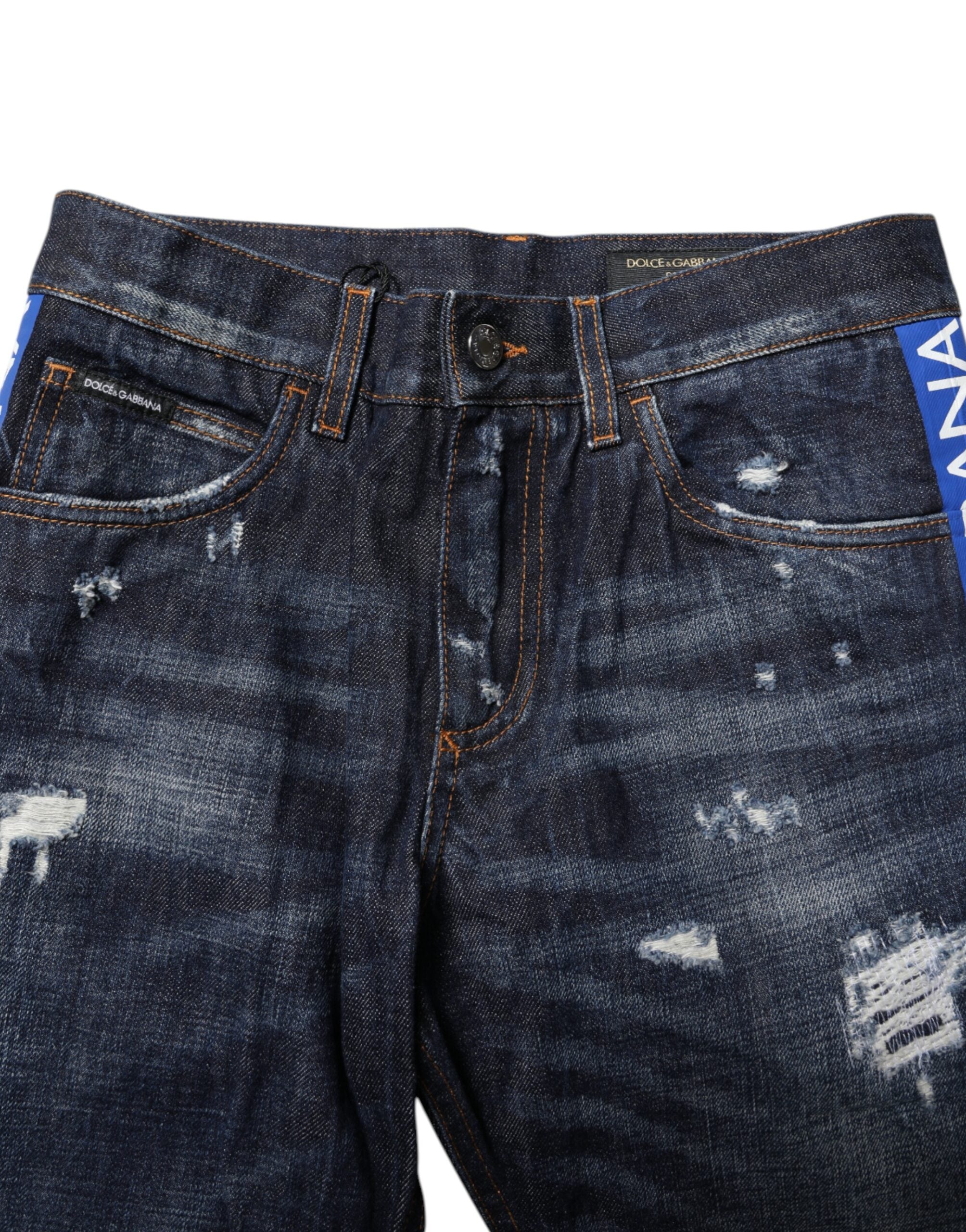 Jeans skinny déchirés bleu foncé Dolce & Gabbana, denim tattered, coupe ajustée, vue de face avec détails déchirés.