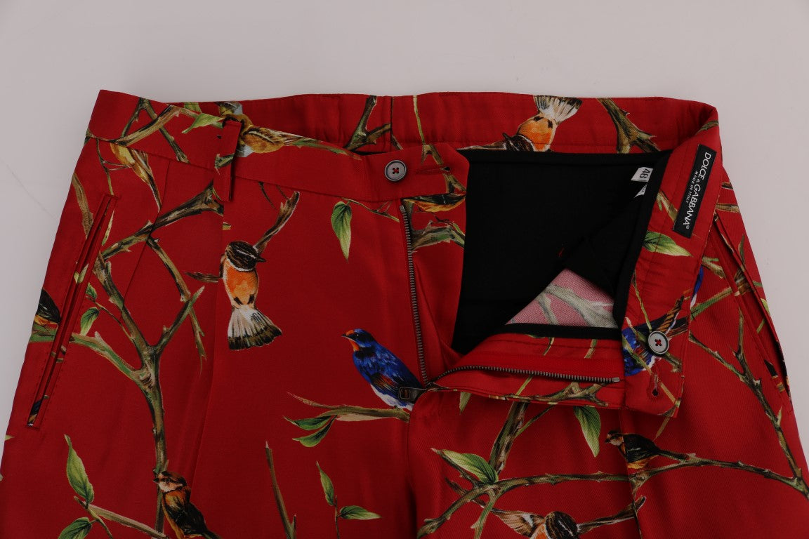 Pantalon de soie rouge Dolce & Gabbana avec motif oiseau élégant et détails raffinés.