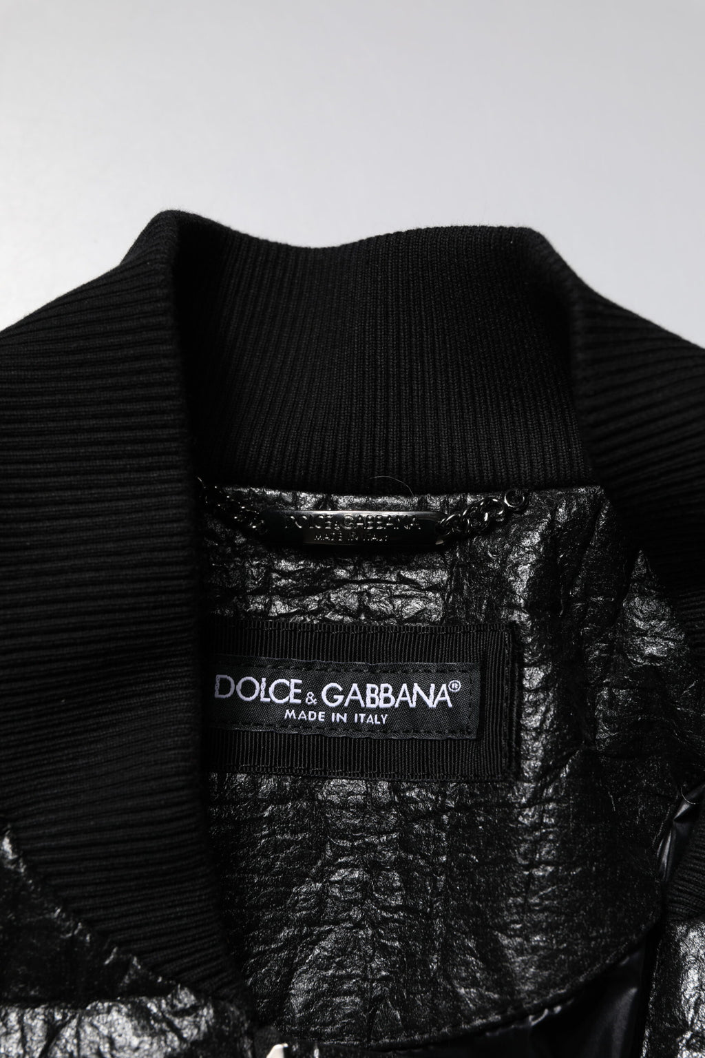Veste bomber noire Dolce & Gabbana avec plaque logo, fermeture éclair complète, style tendance et moderne.