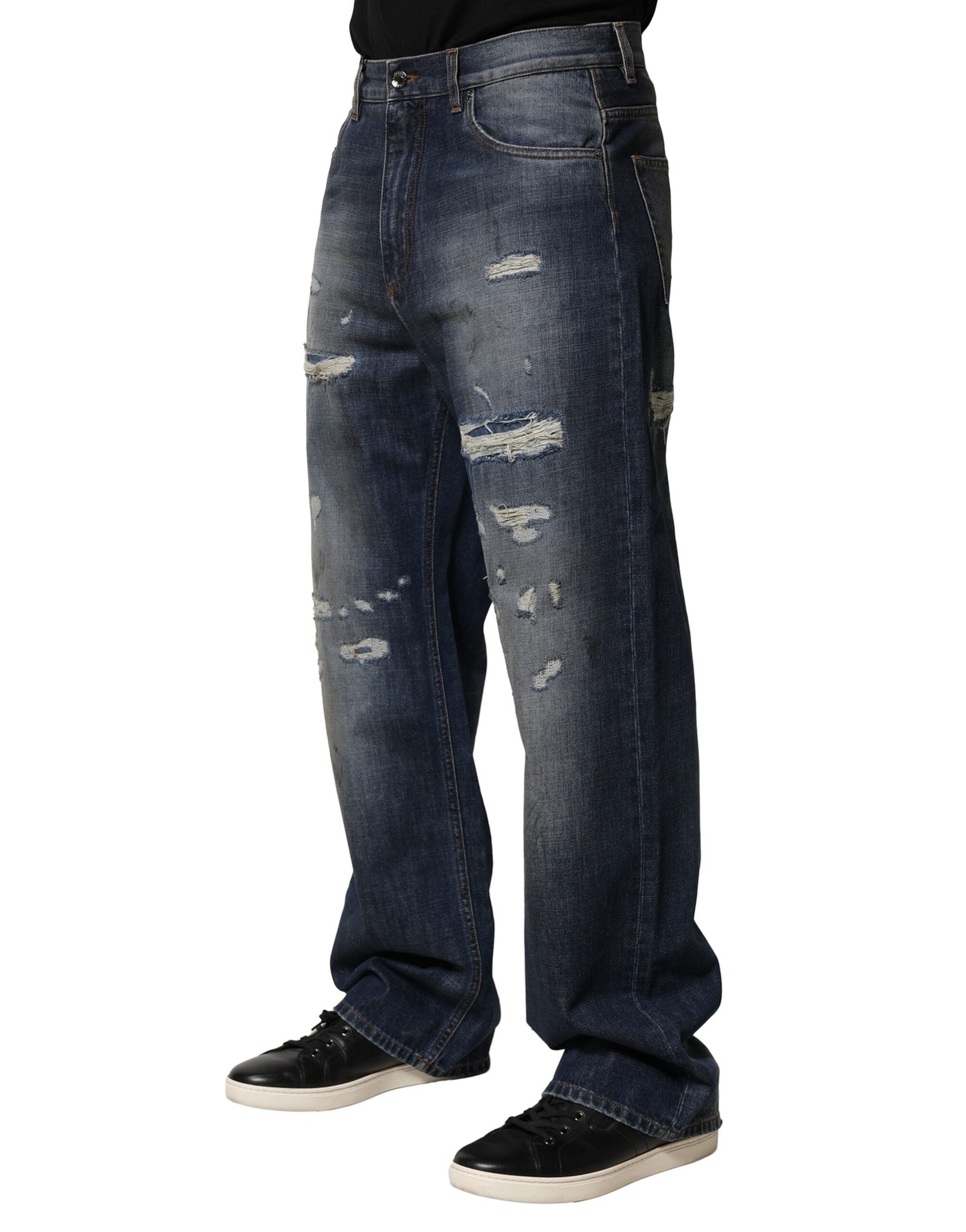 Jean homme en coton bleu délavé et usé de Dolce & Gabbana, style déchiré et tendance, visible en détail dans l'image.