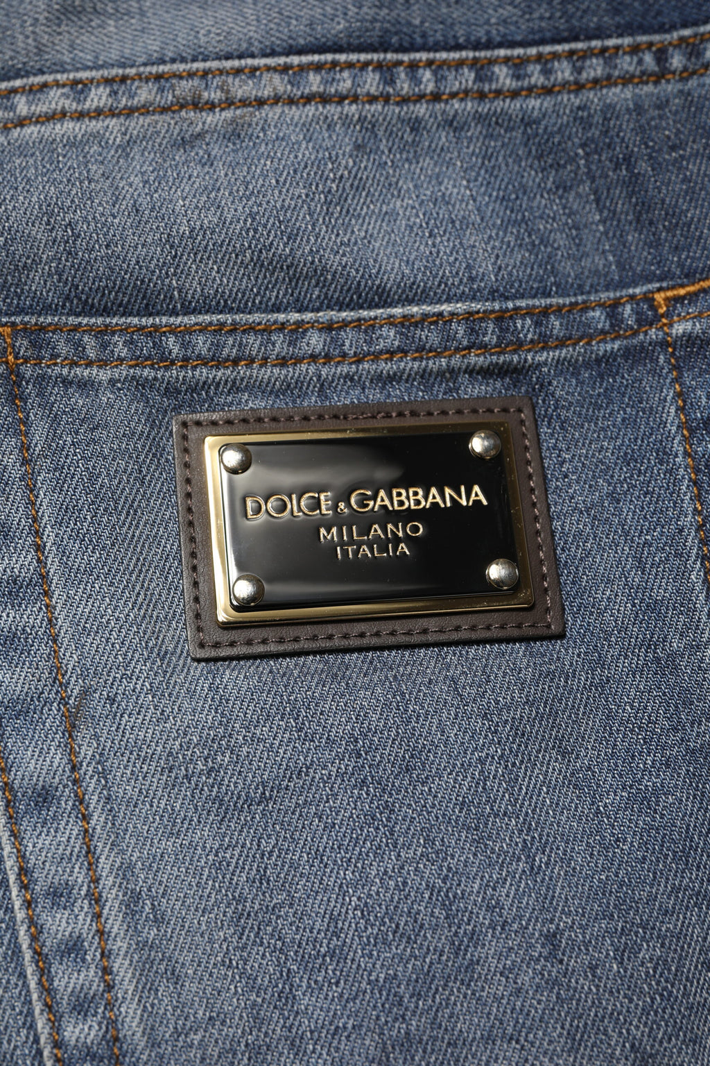 Jeans homme Dolce & Gabbana en coton bleu délavé et usé, style tattered, avec détails déchirés et usés visibles.