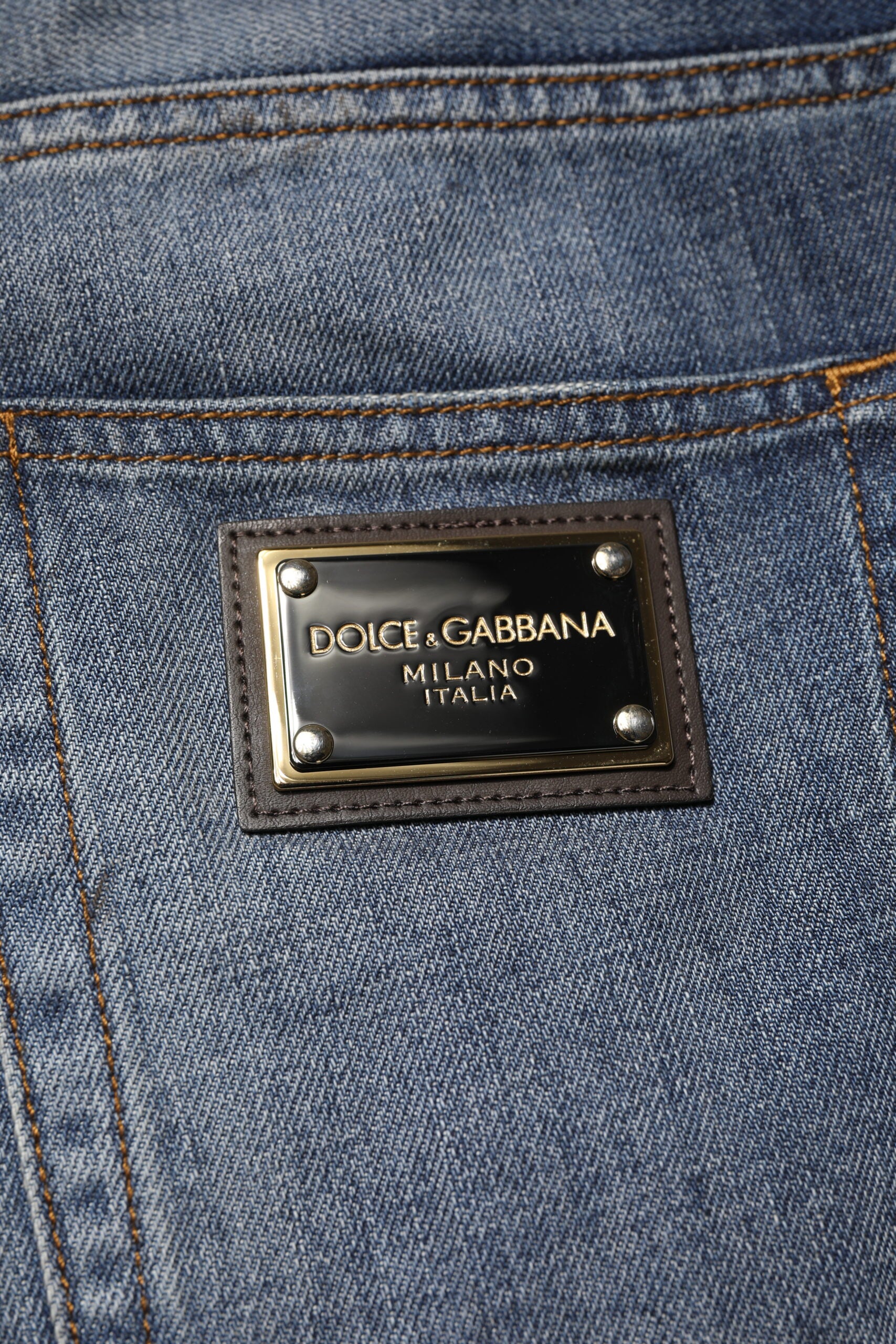 Jeans homme Dolce & Gabbana en coton bleu délavé et usé, style tattered, avec détails déchirés et usés visibles.