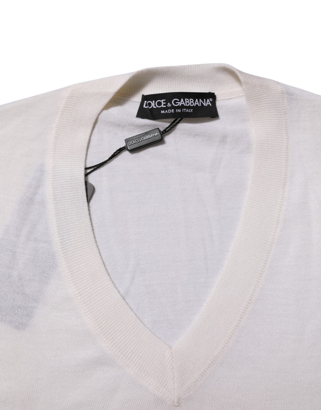 Pull en cachemire blanc Dolce & Gabbana avec logo, col en V et style élégant, visible en gros plan.