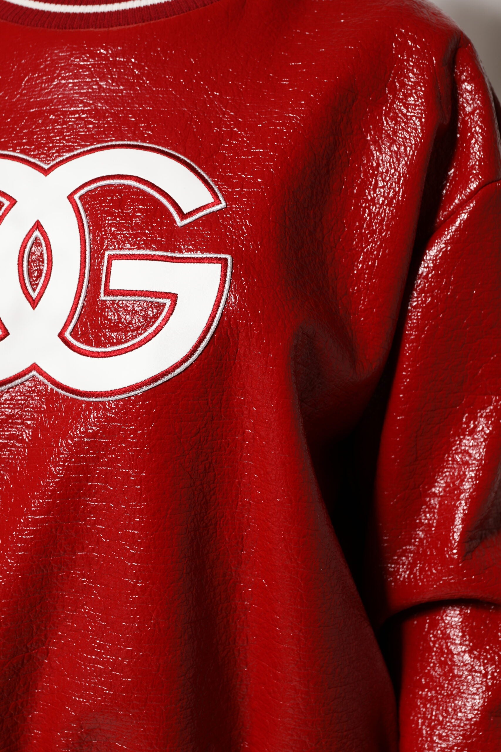 Pull Dolce & Gabbana en laine rouge avec broderie DGLogo, col rond et style élégant, visible sur le pull.