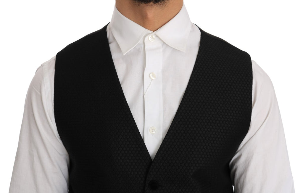 Gilet noir à motif pois Dolce & Gabbana avec détails élégants, porté sur un fond neutre, mettant en valeur le tissu et le design.