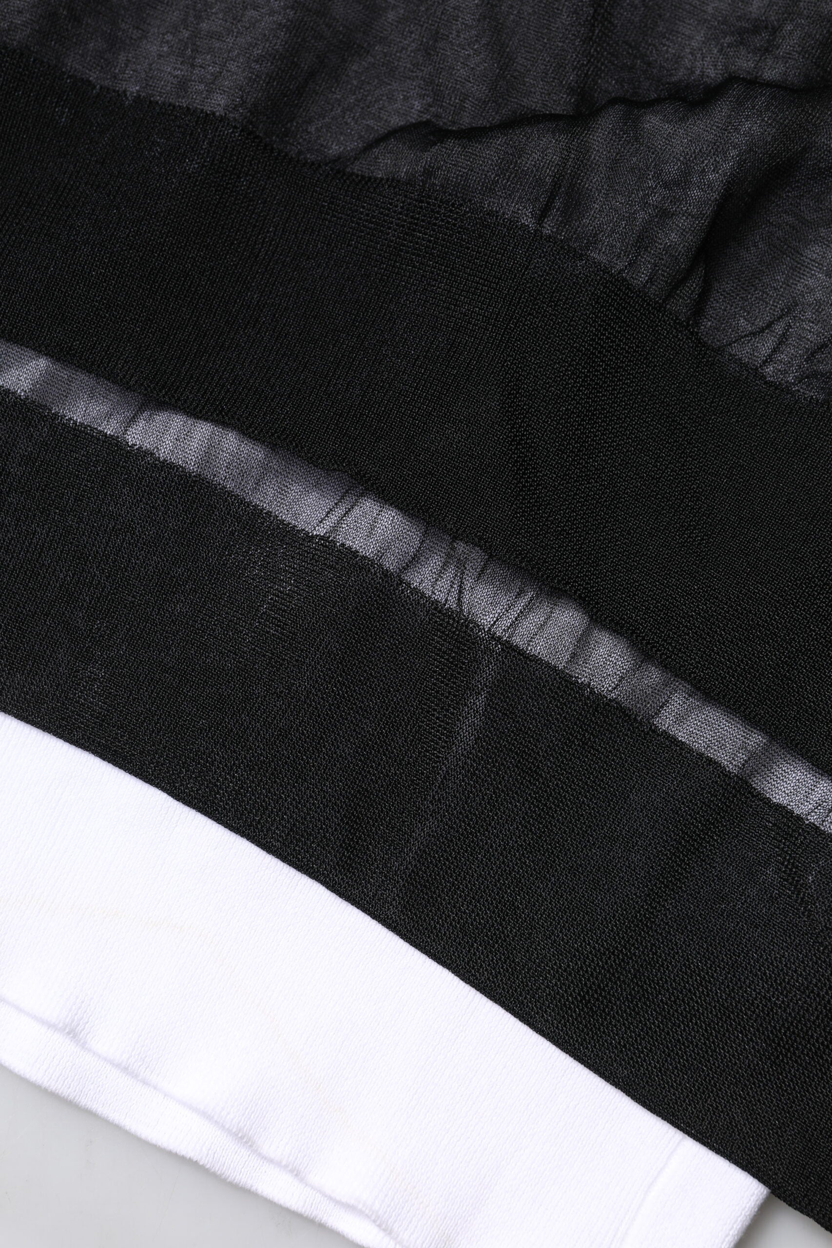 Pull en tricot noir et blanc Dolce & Gabbana avec logo, manches longues, porté sur un mannequin.
