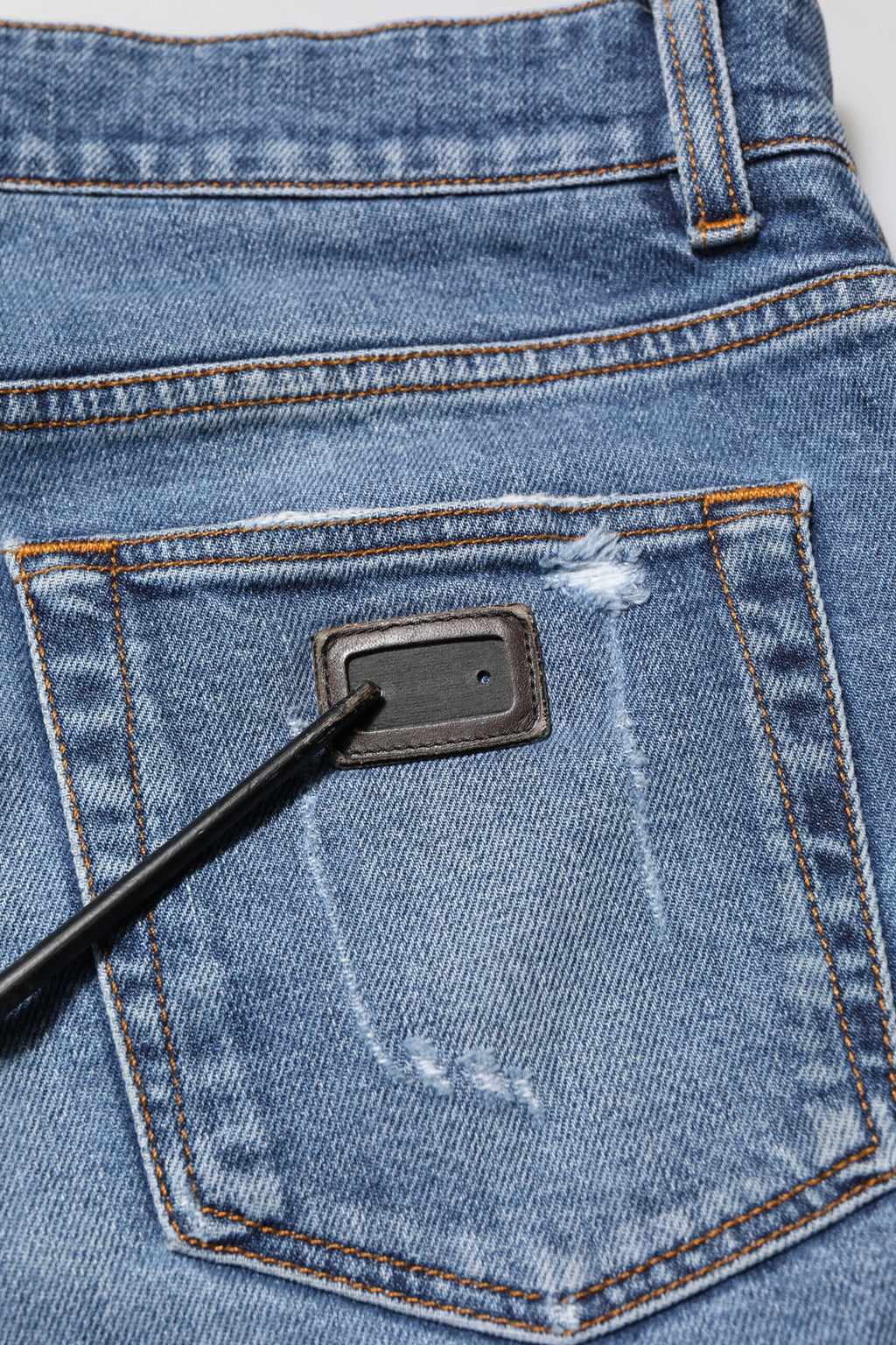Jeans en denim Dolce & Gabbana bleu avec logo en plaque, coupe confort, style décontracté, visible en détail sur l'image.