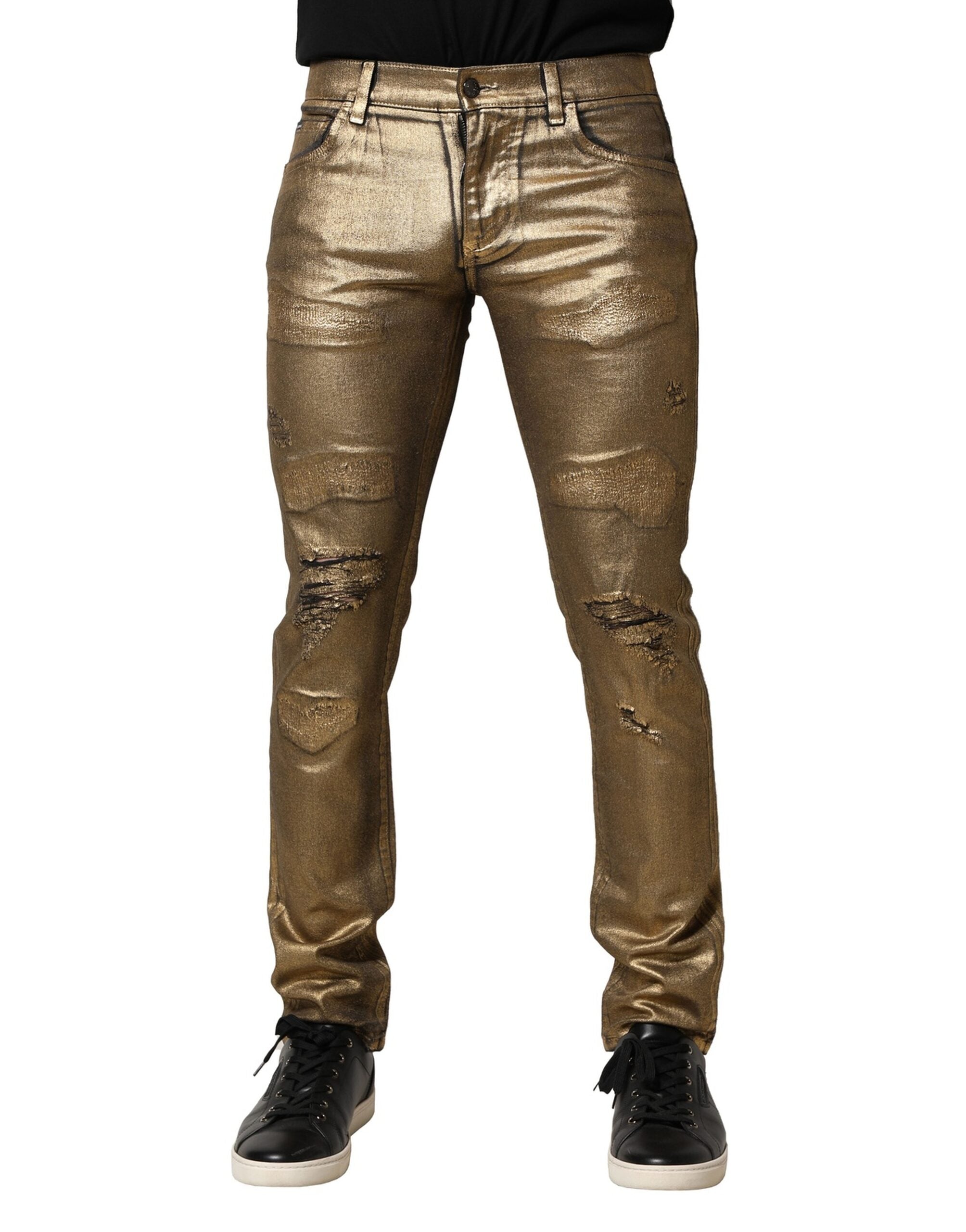 Jeans slim en denim coton stretch tacheté doré de Dolce & Gabbana, style déchiré et tendance, vue en gros plan.