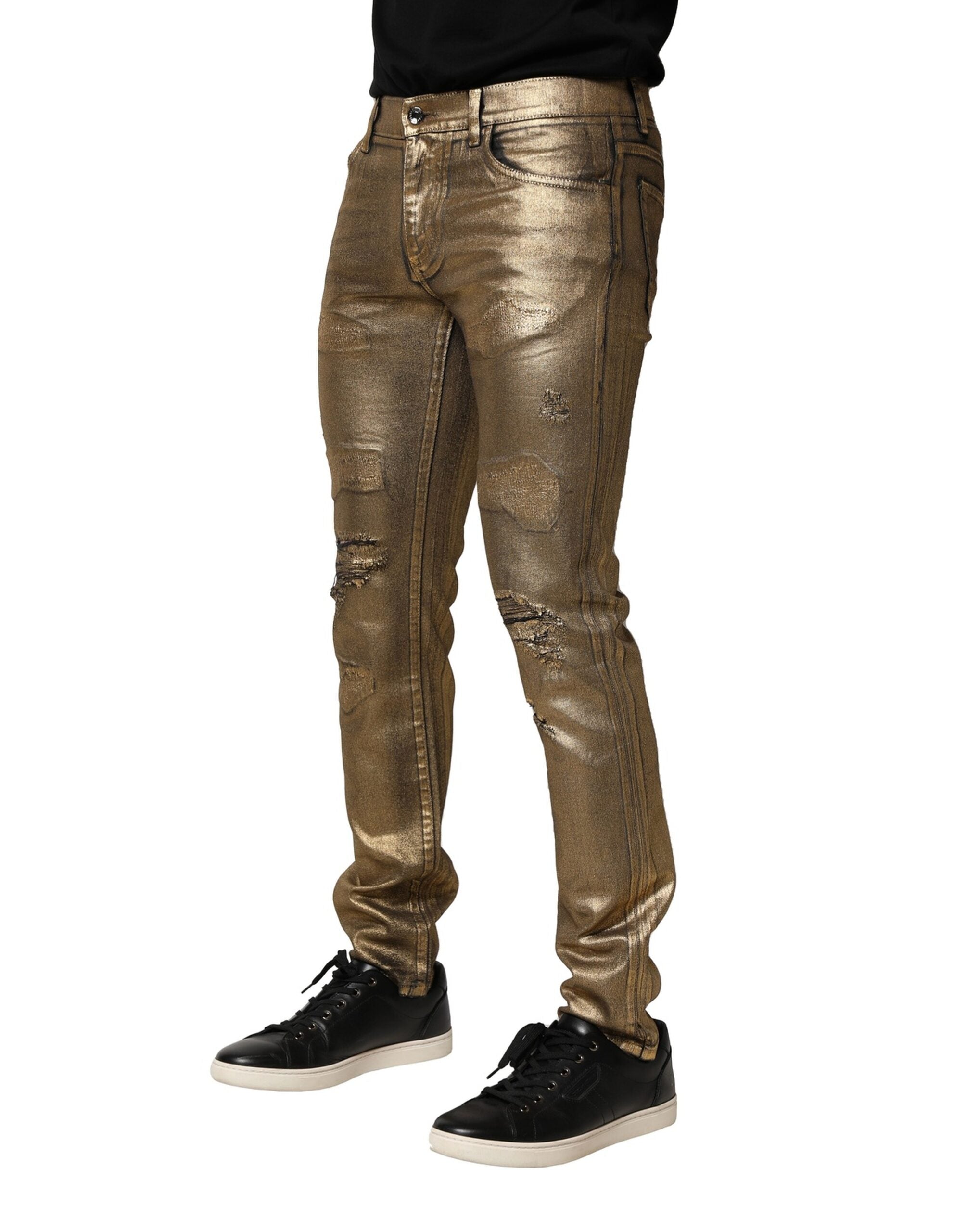 Jeans slim en denim coton stretch doré effiloché de Dolce & Gabbana, avec détails usés et coupe ajustée.