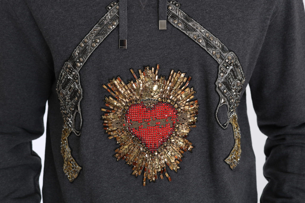 Pull gris à capuche Dolce & Gabbana avec cœur en cristal rouge et motif pistolet, vue de face.