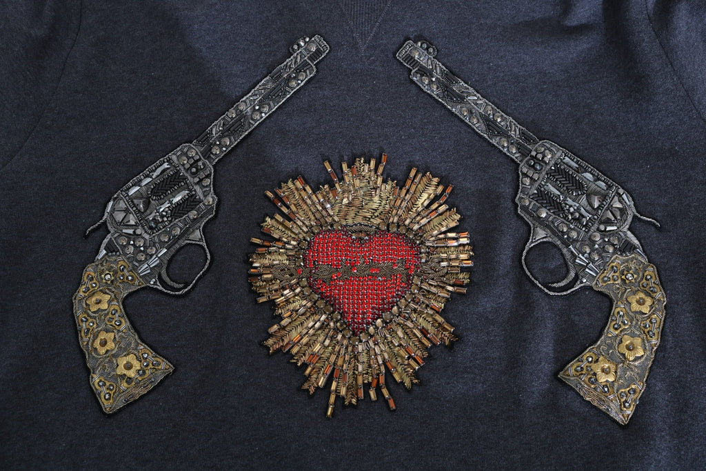 Sweat à capuche gris de Dolce & Gabbana avec cœur en cristal rouge et motif pistolet, style tendance et luxe.