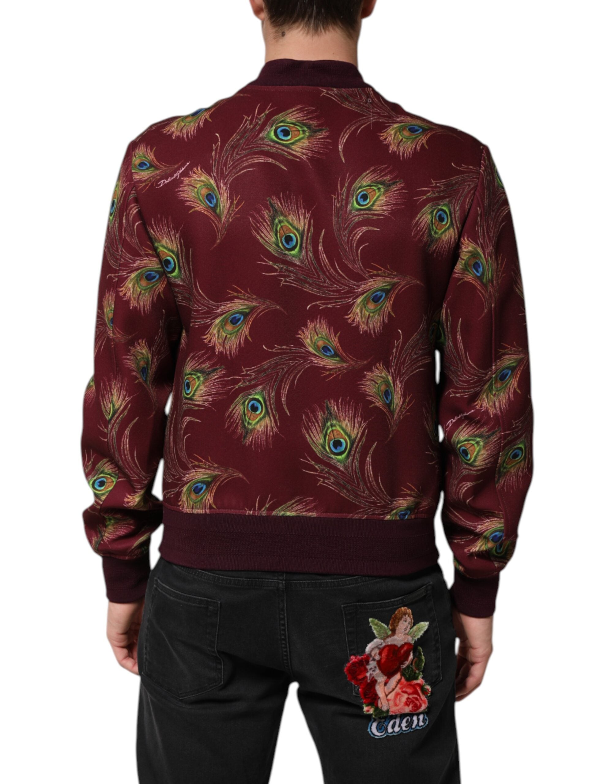 Veste bomber marron Dolce & Gabbana avec motif plumes de paon, tissu élégant et détails sophistiqués.