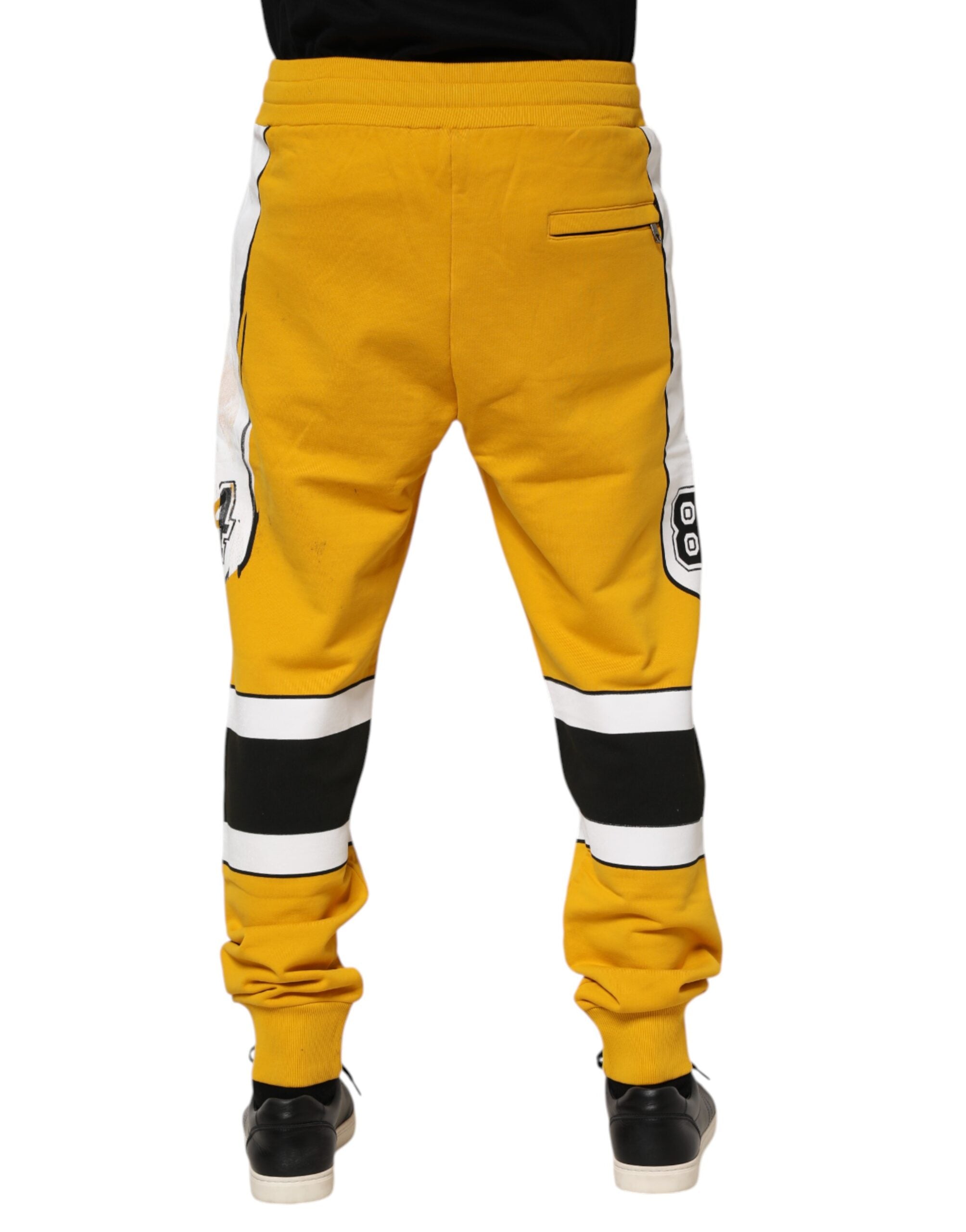 Pantalons jogger en coton jaune imprimé de Dolce & Gabbana, style décontracté et confortable, visible avec détails de design.