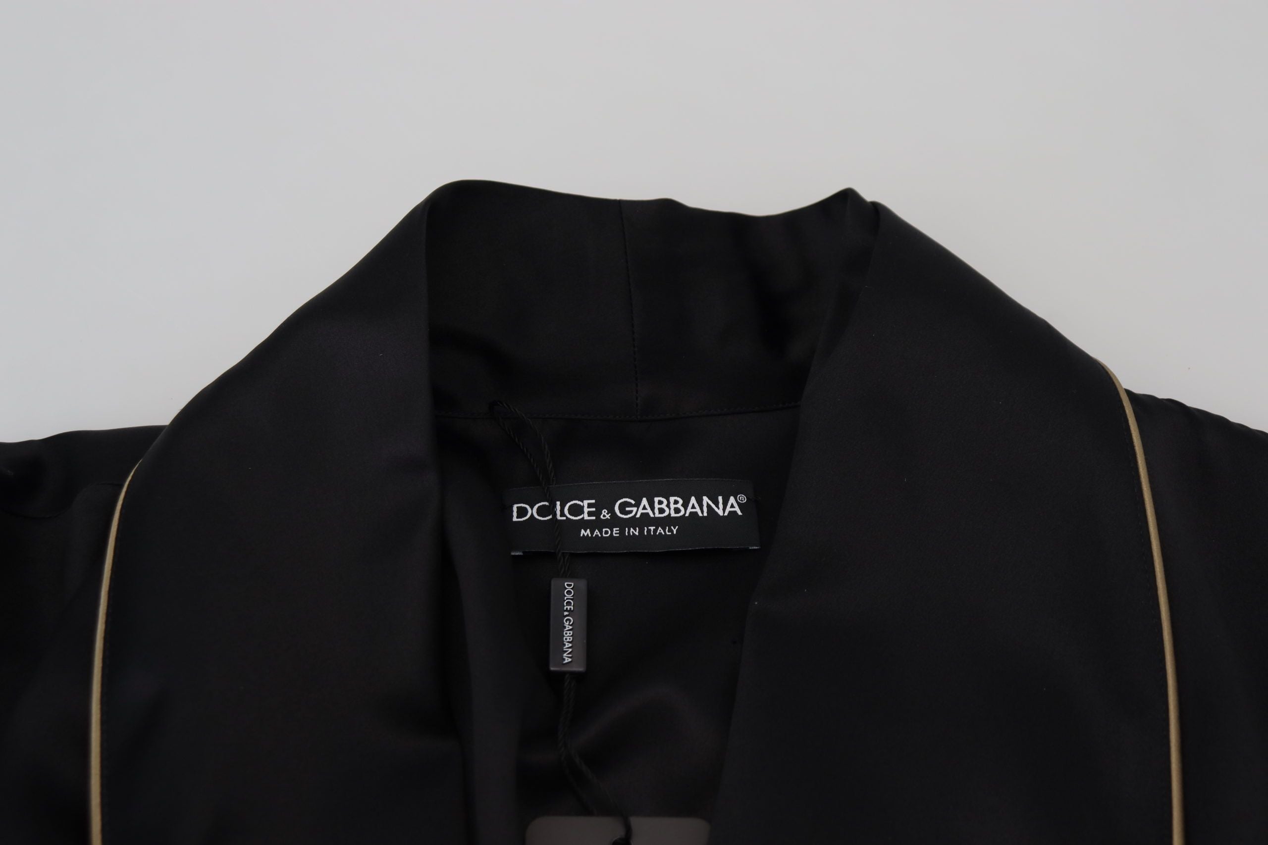 Robe-coat en soie noire Dolce & Gabbana avec ceinture, style wrap, veste élégante en tissu brillant.