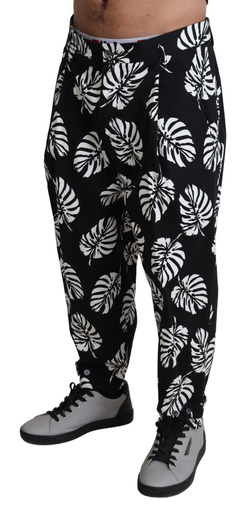 Pantalon noir Dolce & Gabbana en coton stretch avec motif de feuilles, coupe élégante et moderne.