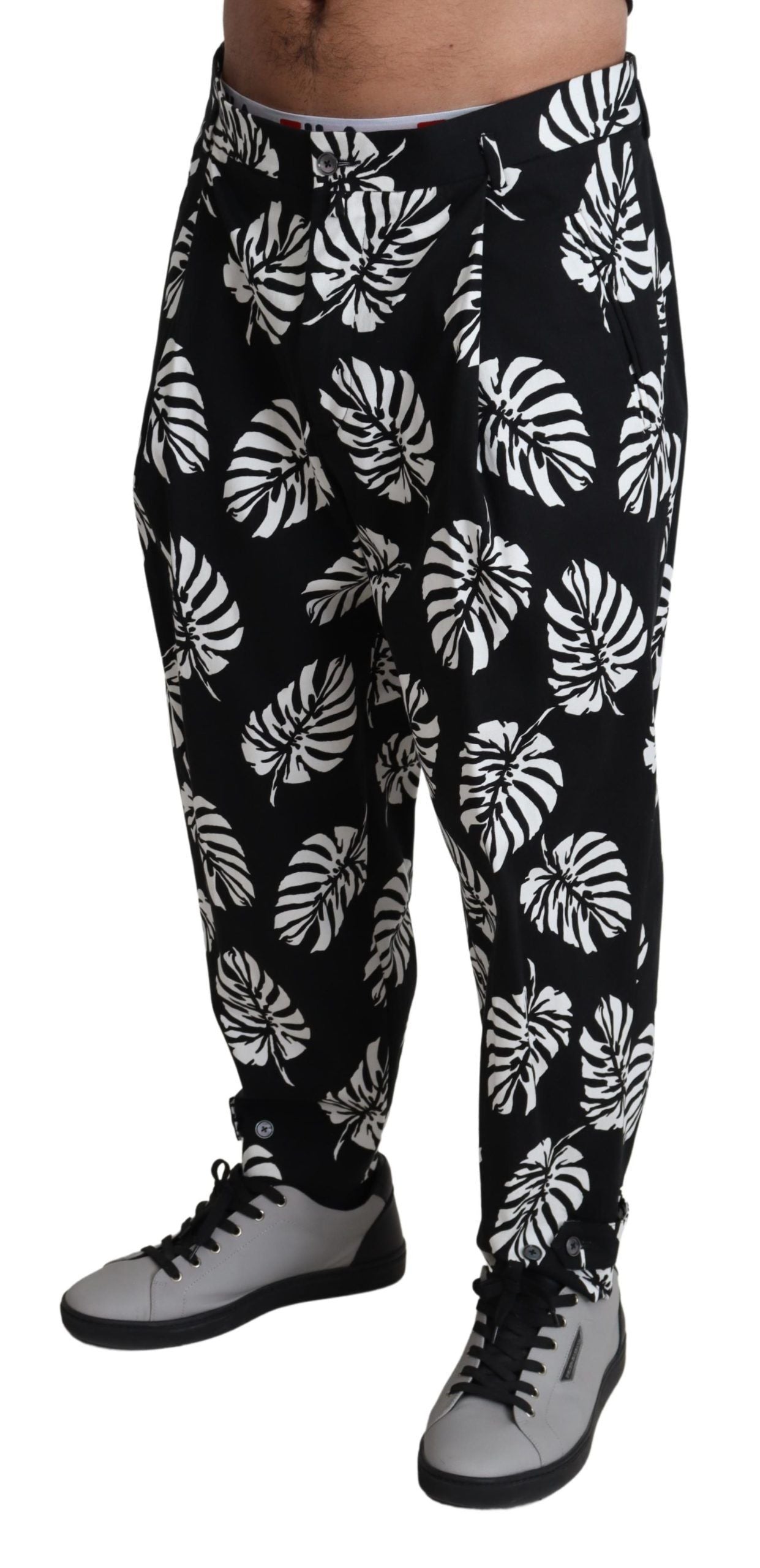 Pantalon noir Dolce & Gabbana en coton stretch avec motif de feuilles, coupe élégante et moderne.