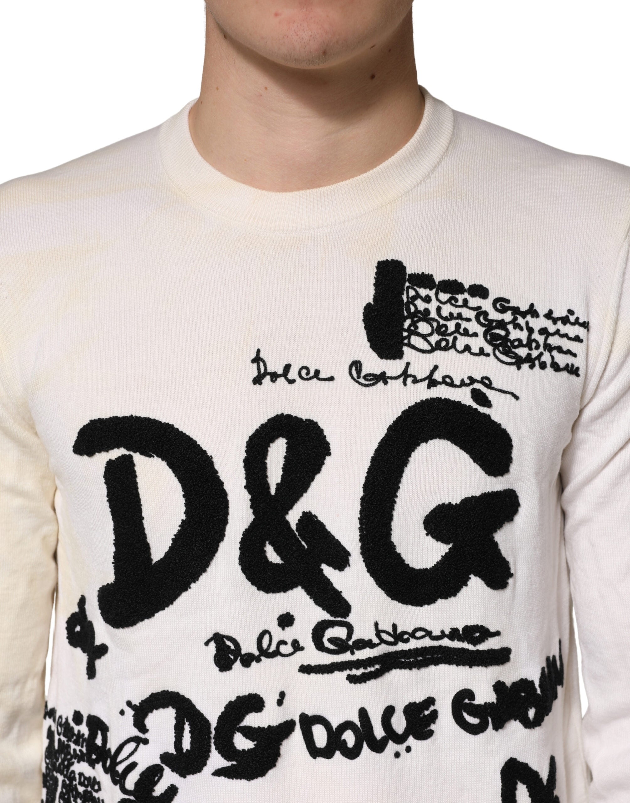Pull blanc Dolce & Gabbana en laine vierge avec logo graphique, col ras du cou et design moderne visible sur l'image.