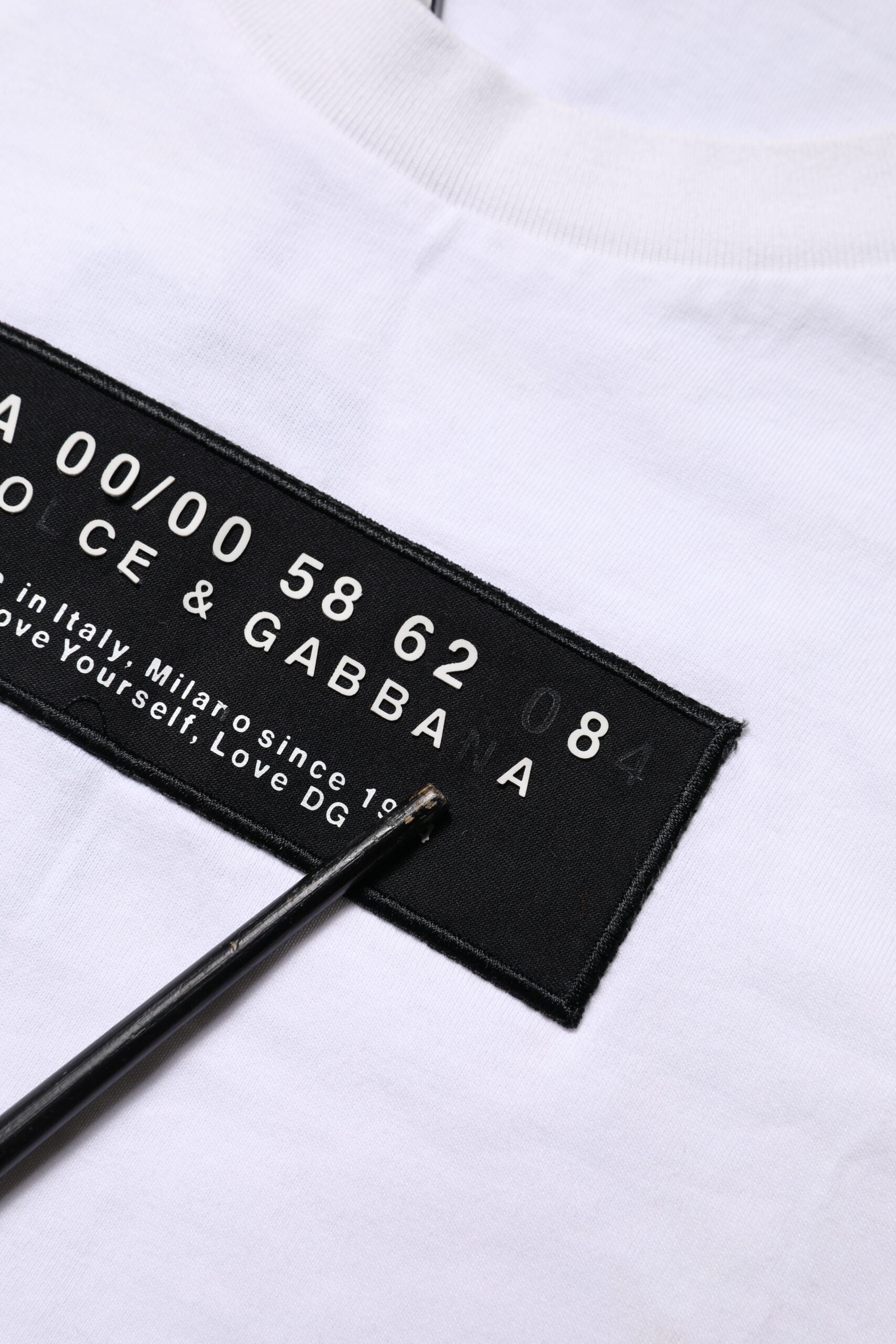 T-shirt blanc en coton Dolce & Gabbana avec logo brodé sur le patch au col rond, vue de face.