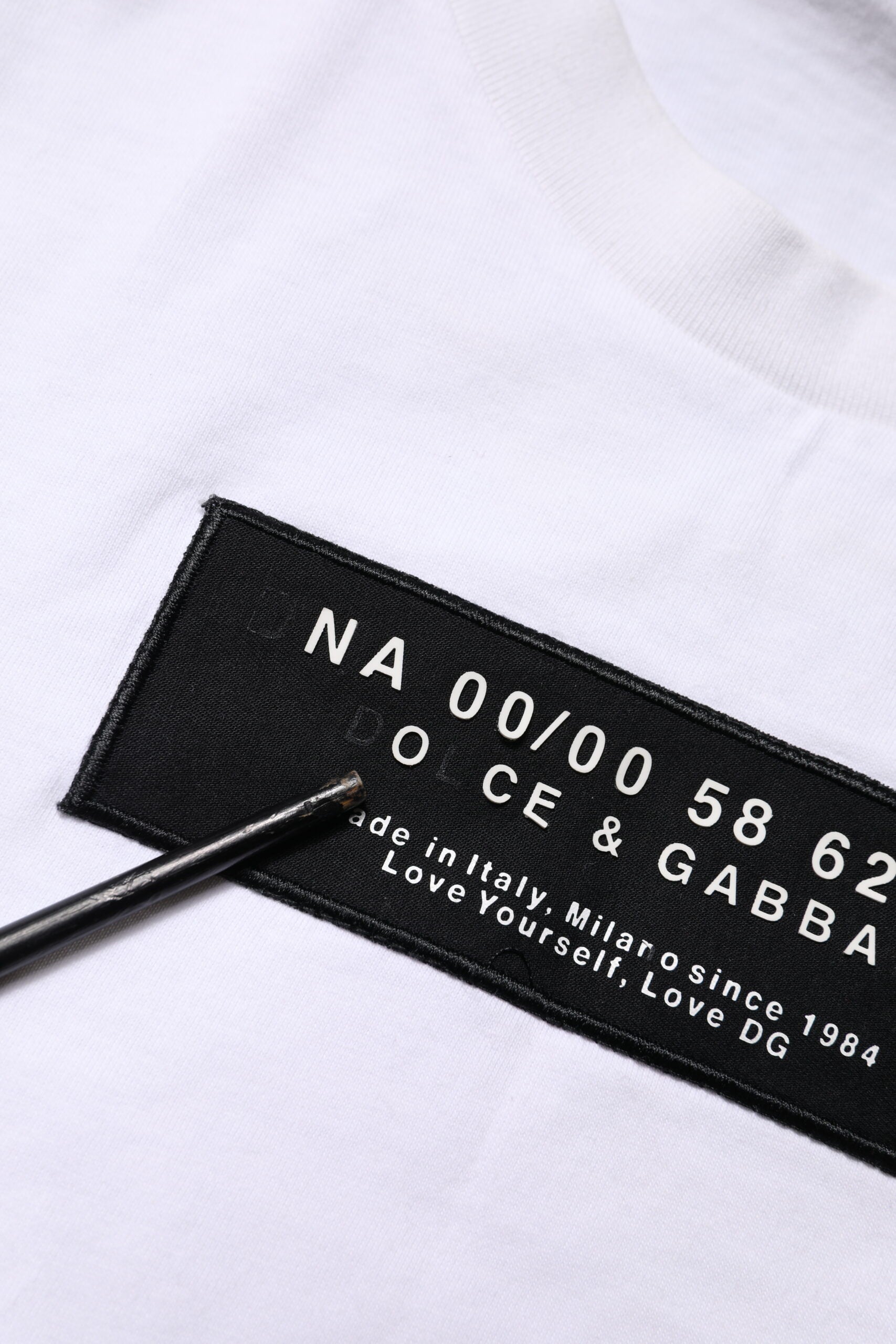 T-shirt blanc en coton Dolce & Gabbana avec logo patch sur le col rond, style décontracté et élégant.