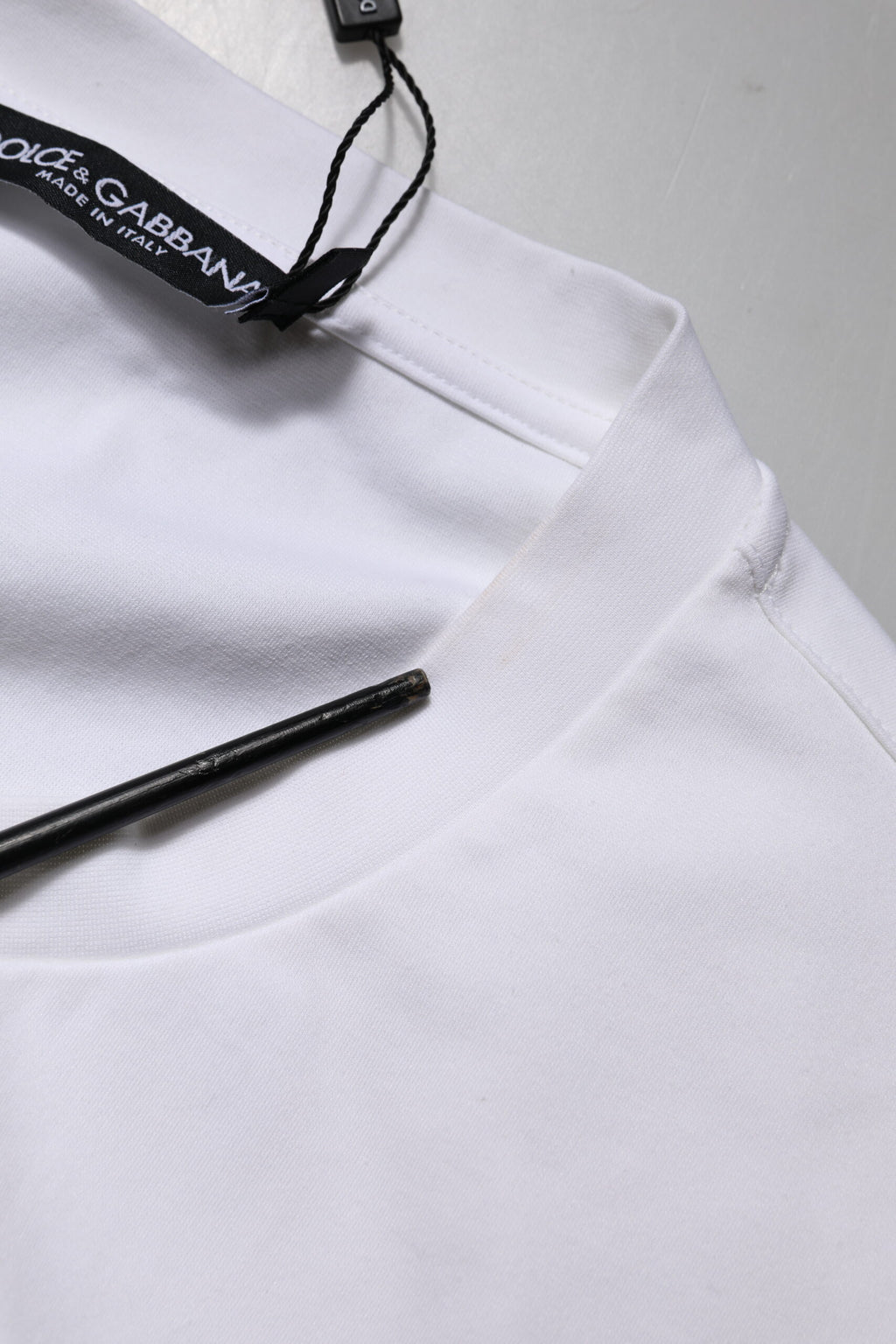 T-shirt blanc Dolce & Gabbana à manches courtes avec logo orné, style décontracté et élégant, visible sur l'image.