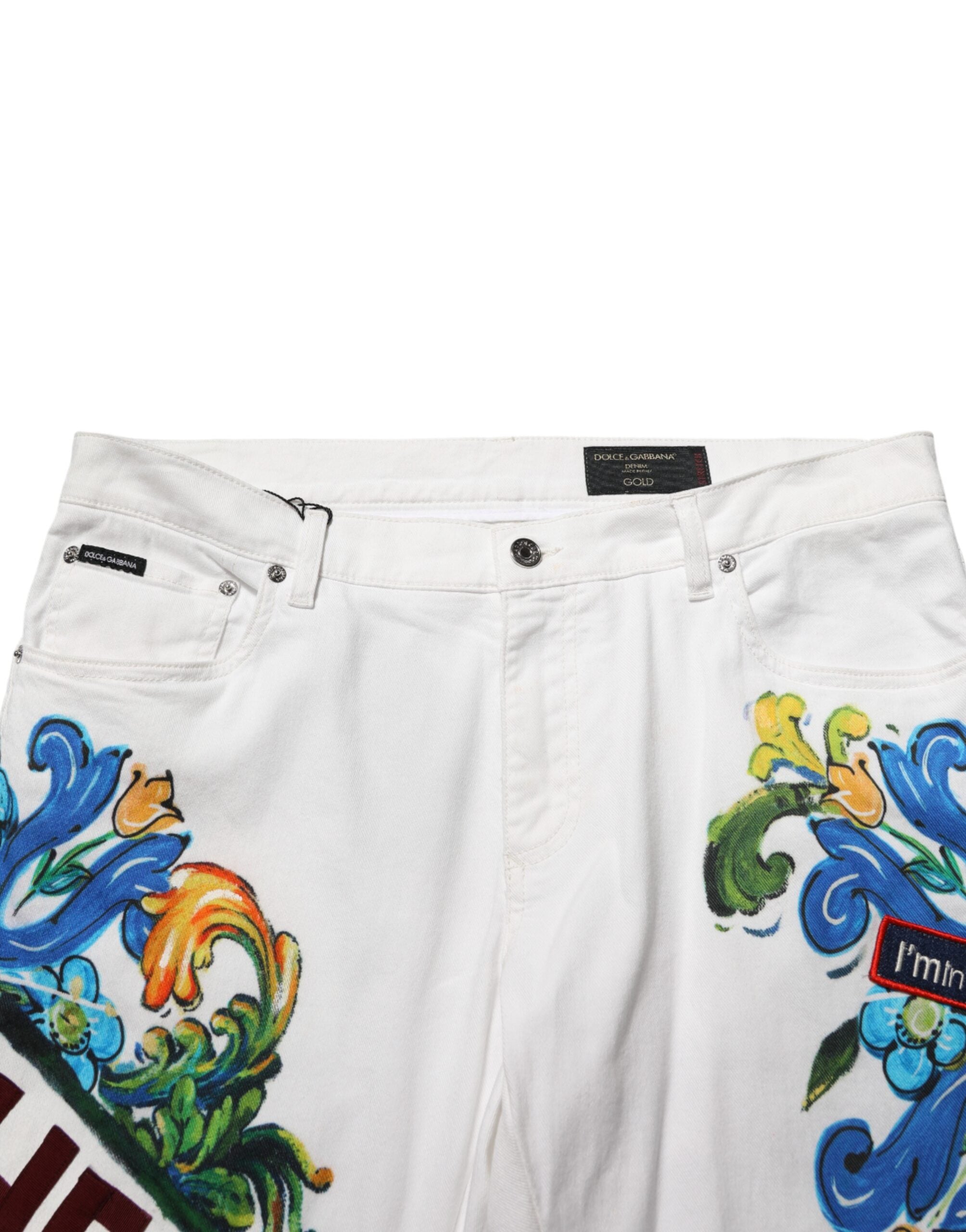 Jeans skinny en denim doré Dolce & Gabbana avec imprimé graffiti blanc, coupe ajustée et détails tendance.