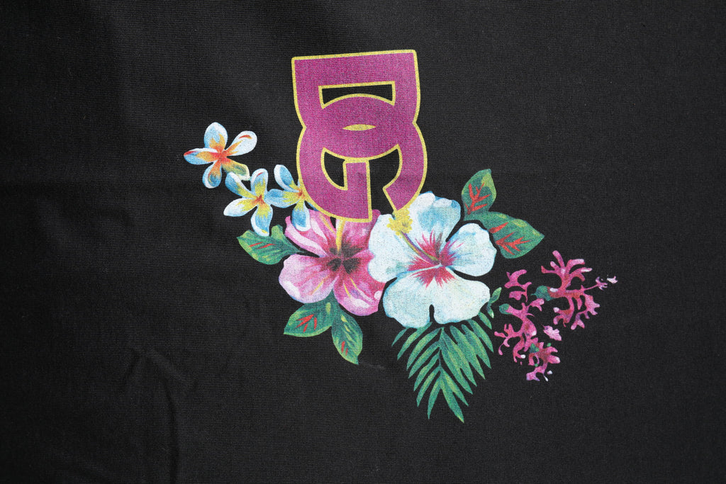 T-shirt à col rond noir Dolce & Gabbana avec imprimé floral DG, visible en gros plan sur fond neutre.