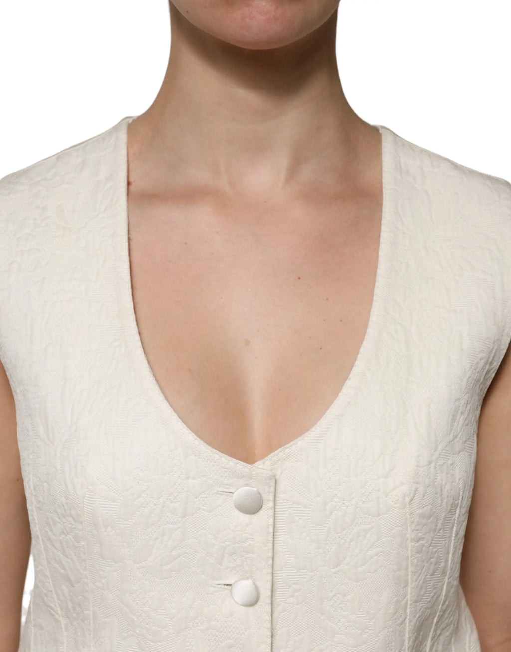 Dolce & Gabbana top sans manches ivoire en coton avec col en v profond et boutons assortis sur le devant texturé