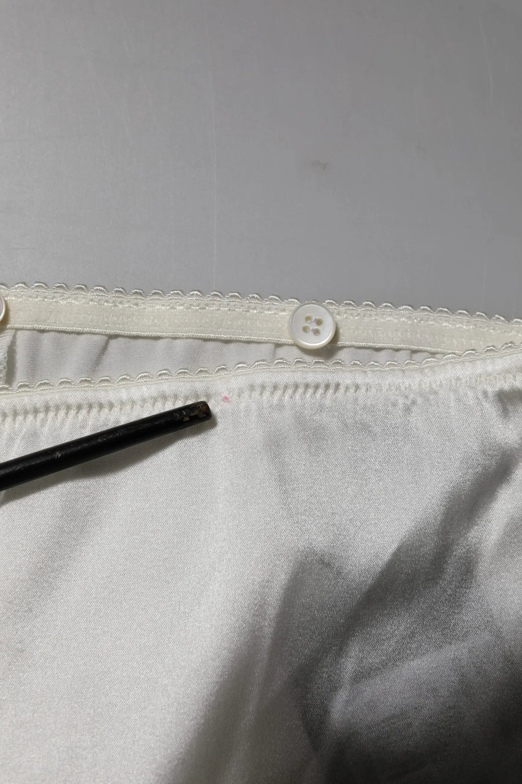 Intérieur en satin blanc avec taille élastique festonnée et bouton blanc du pantalon ivoire en soie dolce & gabbana