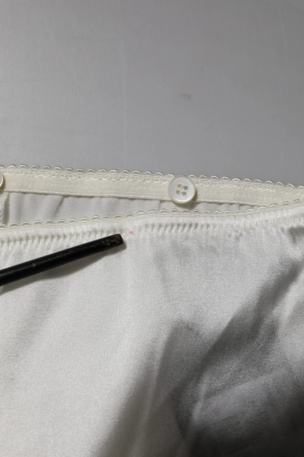 Intérieur en satin blanc avec taille élastique festonnée et bouton blanc du pantalon ivoire en soie dolce & gabbana