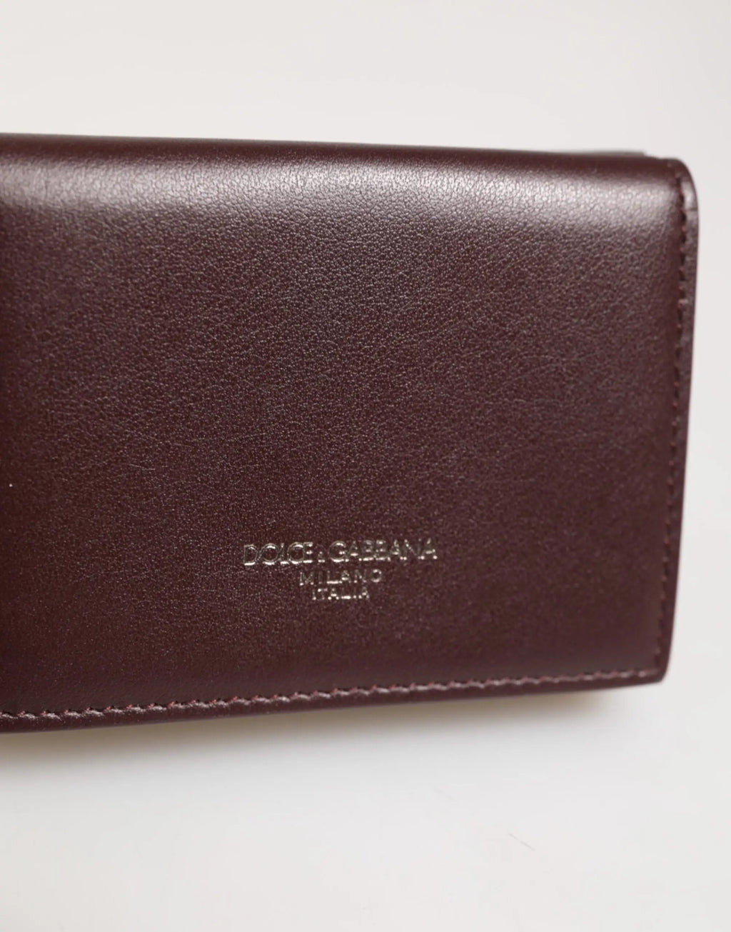 Un portefeuille trifold pour homme en cuir brun foncé avec logo dolce & gabbana milano italia embossé subtil