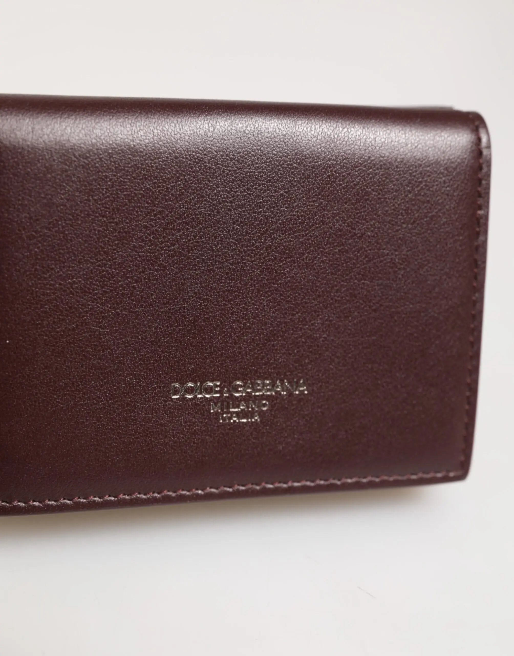 Un portefeuille trifold pour homme en cuir brun foncé avec logo dolce & gabbana milano italia embossé subtil