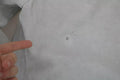Petite déchirure en tissu blanc sur chemise en coton gris clair sous veste blanche biker en cuir dolce & gabbana