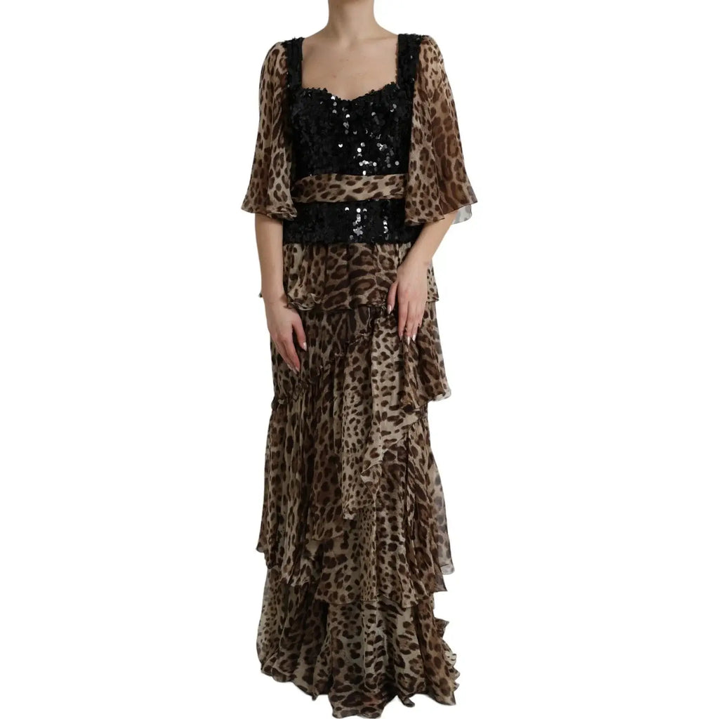 Une femme porte une robe maxi dolce & gabbana en soie à imprimé léopard avec volants, manches transparentes et corsage pailleté noir