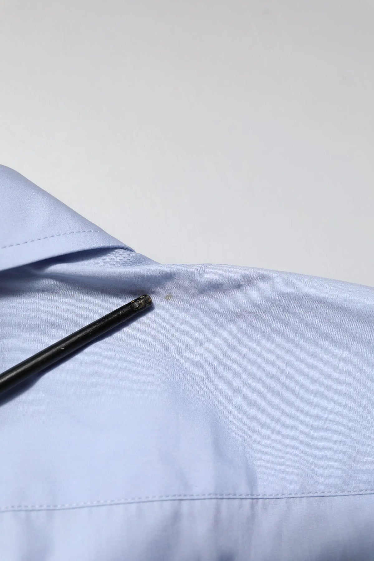 Col bleu clair chemise en coton dolce gabbana manches longues avec un stylo noir posé sur le tissu