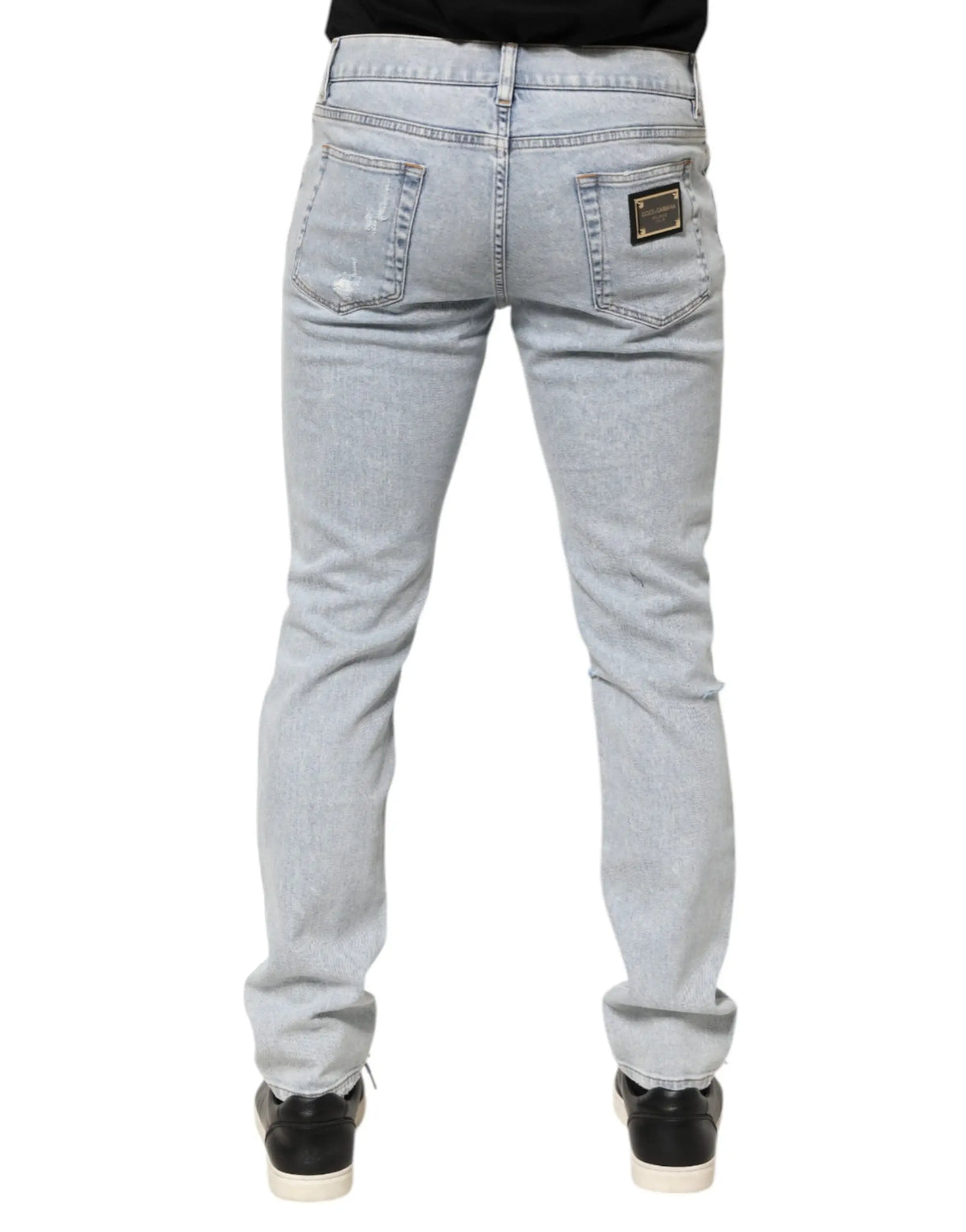 Jeans slim fit en denim bleu clair délavé avec déchirures subtiles et patch Dolce & Gabbana au dos à droite