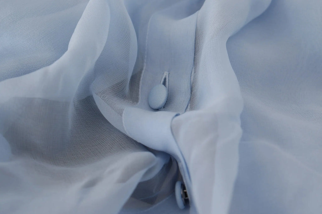 Tissu léger bleu clair en soie avec col ascot et manches longues de dolce gabbana aux plis doux et texture subtile