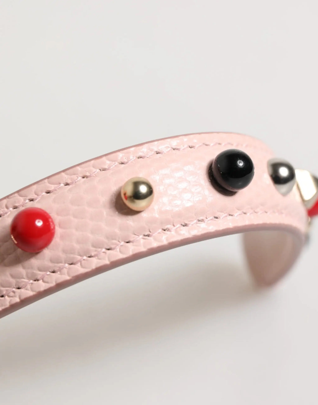 Bracelet en cuir rose texturé dolce & gabbana orné de clous sphériques rouges noirs et dorés pour anse de sac