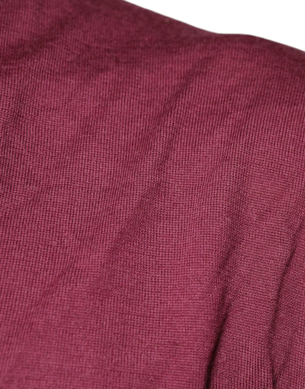 Gros plan sur un tissu en maille bordeaux doux et texturé avec nervures verticales subtile pour pull en cachemire dolce gabbana homme col v