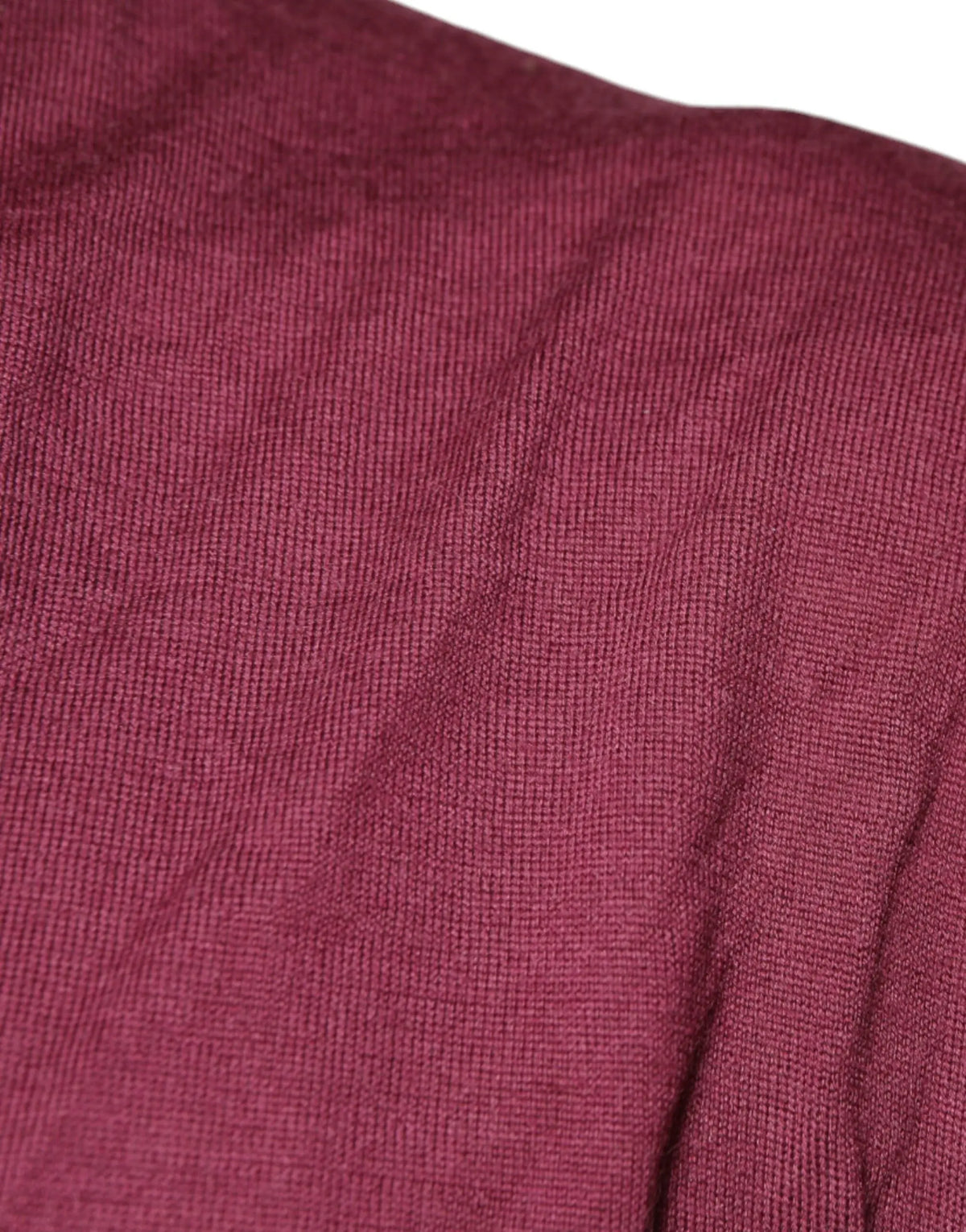 Gros plan sur un tissu en maille bordeaux doux et texturé avec nervures verticales subtile pour pull en cachemire dolce gabbana homme col v