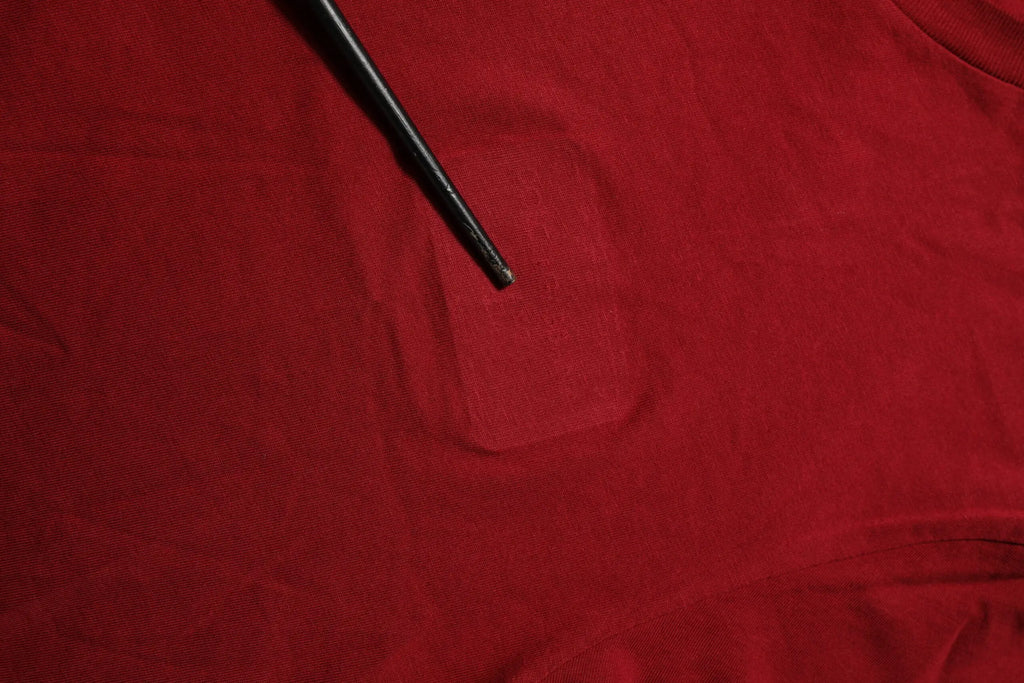 Bâton noir posé sur tissu rouge avec t-shirt dolce & gabbana maroon logo col rond manches courtes