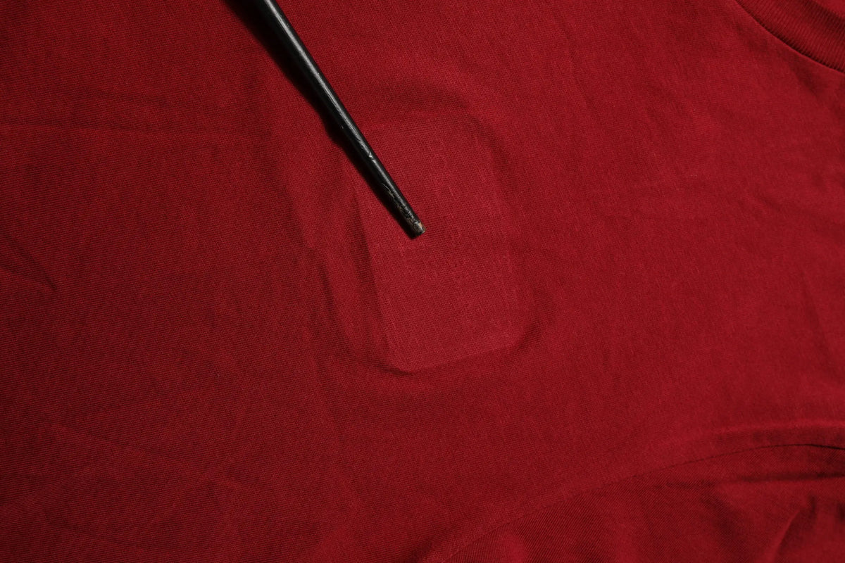 Bâton noir posé sur tissu rouge avec t-shirt dolce & gabbana maroon logo col rond manches courtes