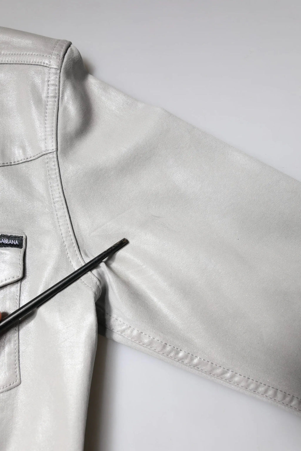 Veste en cuir blanc cassé avec un léger éclat et coutures précises, associée à une chemise boutonnée grise métallique dolce & gabbana en coton