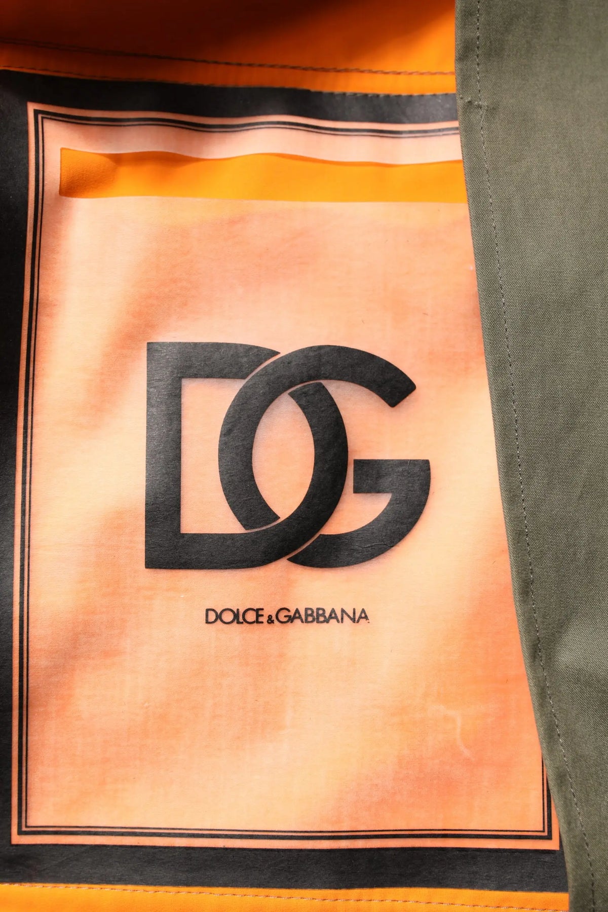 Patch en tissu orange et noir avec logo dolce & gabbana sur veste à capuche camouflage multicolore