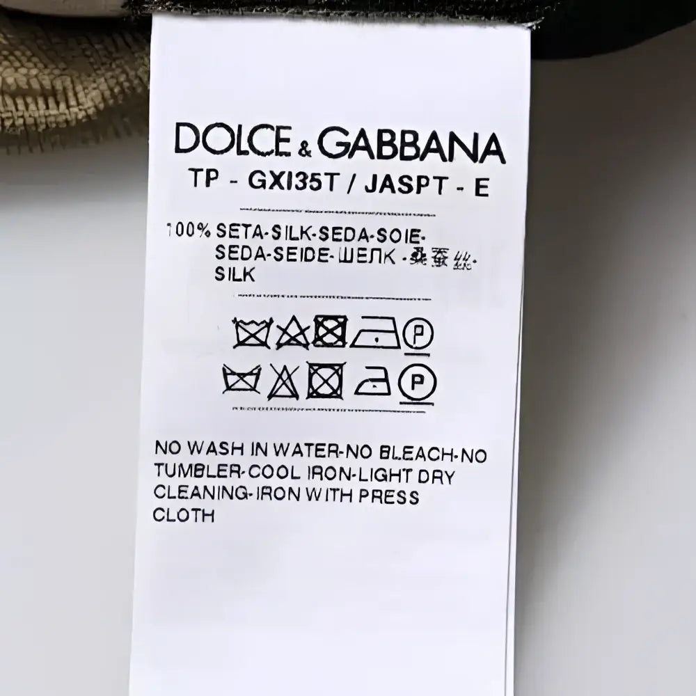 Étiquette de soin blanche en soie dolce & gabbana avec texte noir sur polo multicolore camouflage col en coton