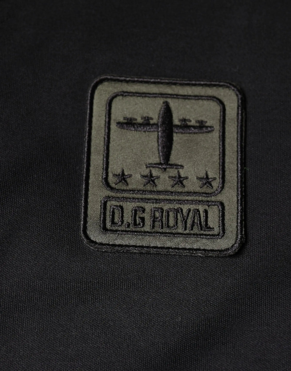 Olive green embroidered patch with stylized aircraft and four stars on dolce gabbana multicolor camouflage cotton t shirt